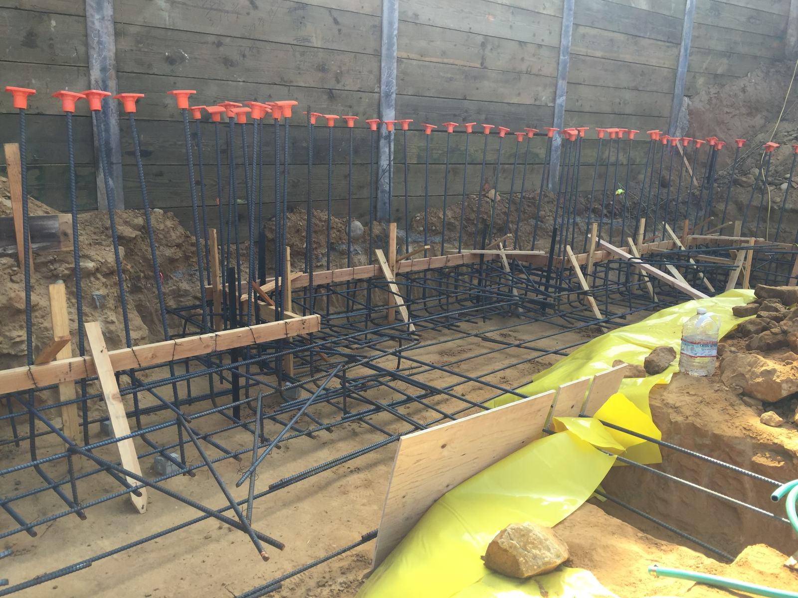Footing forms and reinforcing running along the shoring wall