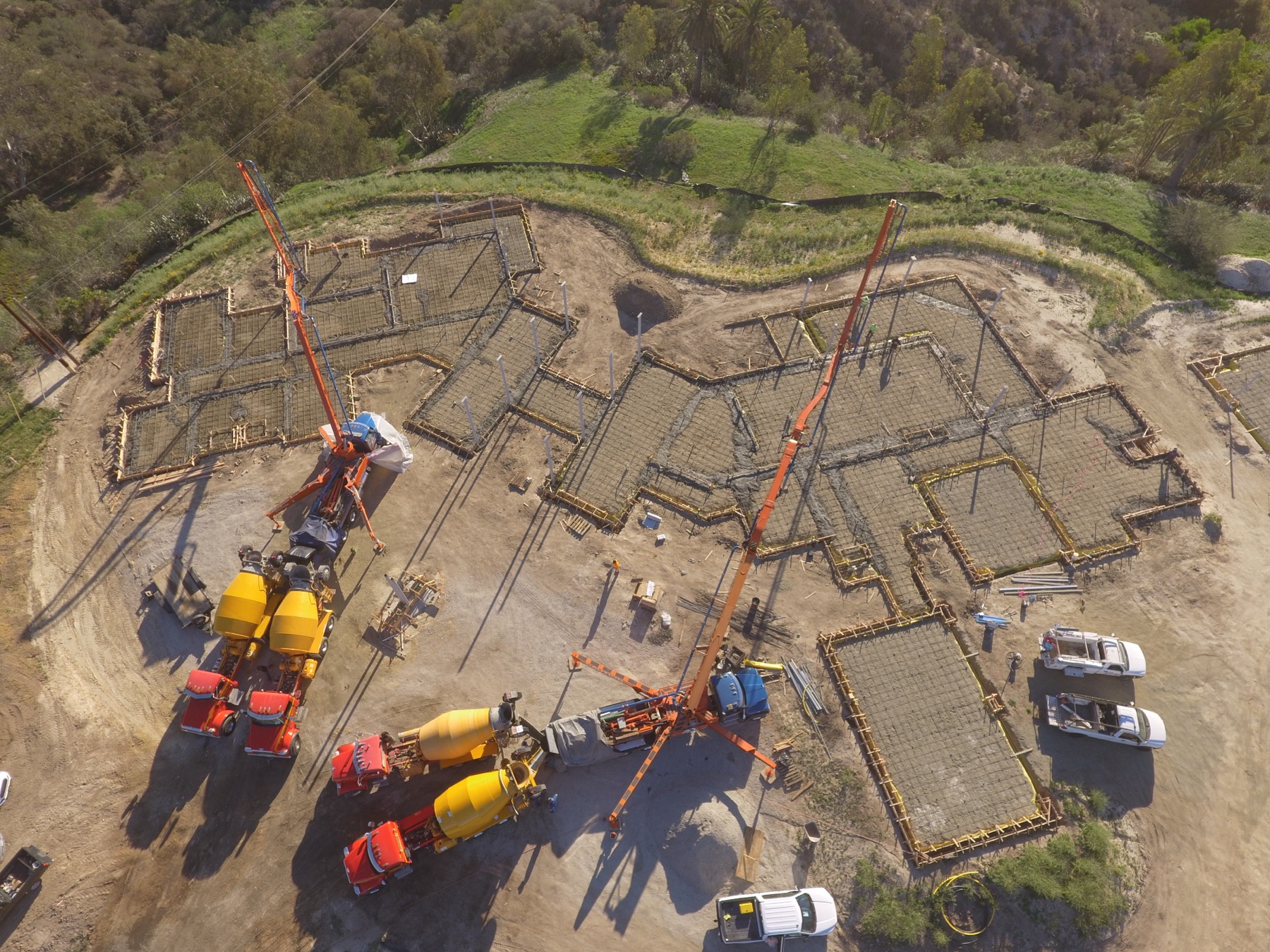 Drone aerial of the 4x8 foundation pour at Linea Del Cielo — footings, stem walls and pump crews