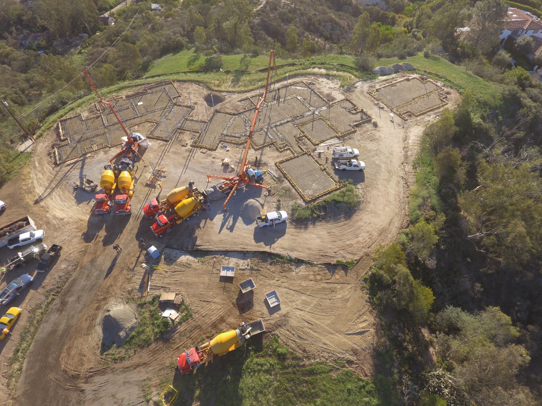 Drone aerial of the 4x8 foundation pour at Linea Del Cielo — footings, stem walls and pump crews
