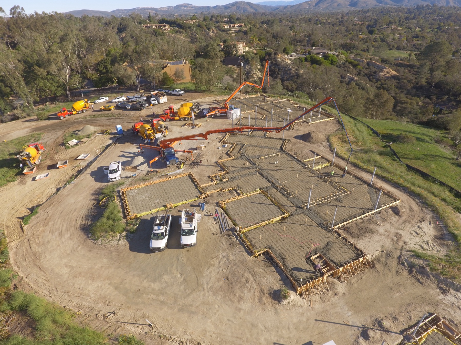 Drone aerial of the 4x8 foundation pour at Linea Del Cielo — footings, stem walls and pump crews