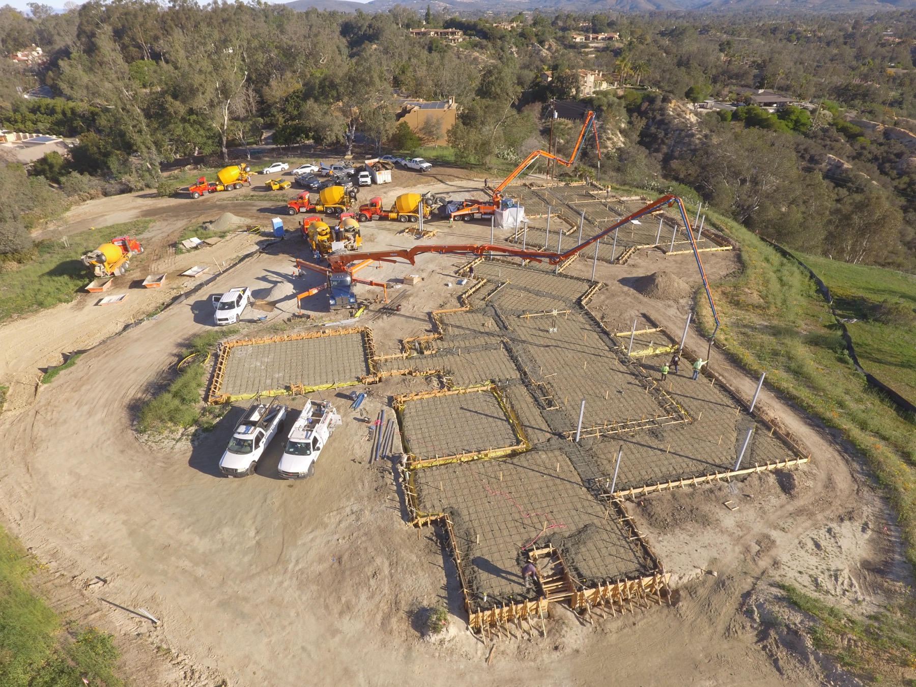 Drone aerial of the 4x8 foundation pour at Linea Del Cielo — footings, stem walls and pump crews