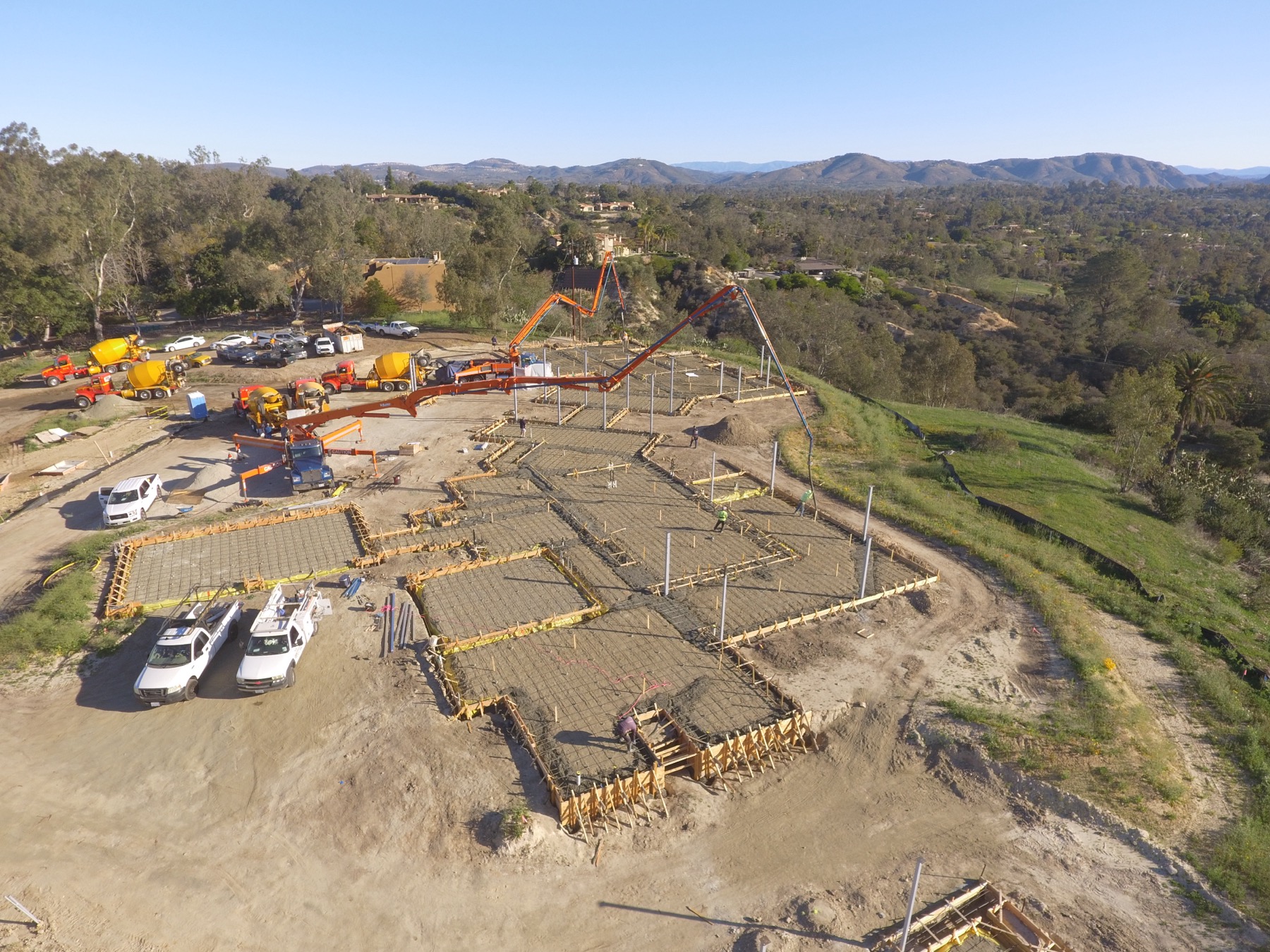 Drone aerial of the 4x8 foundation pour at Linea Del Cielo — footings, stem walls and pump crews