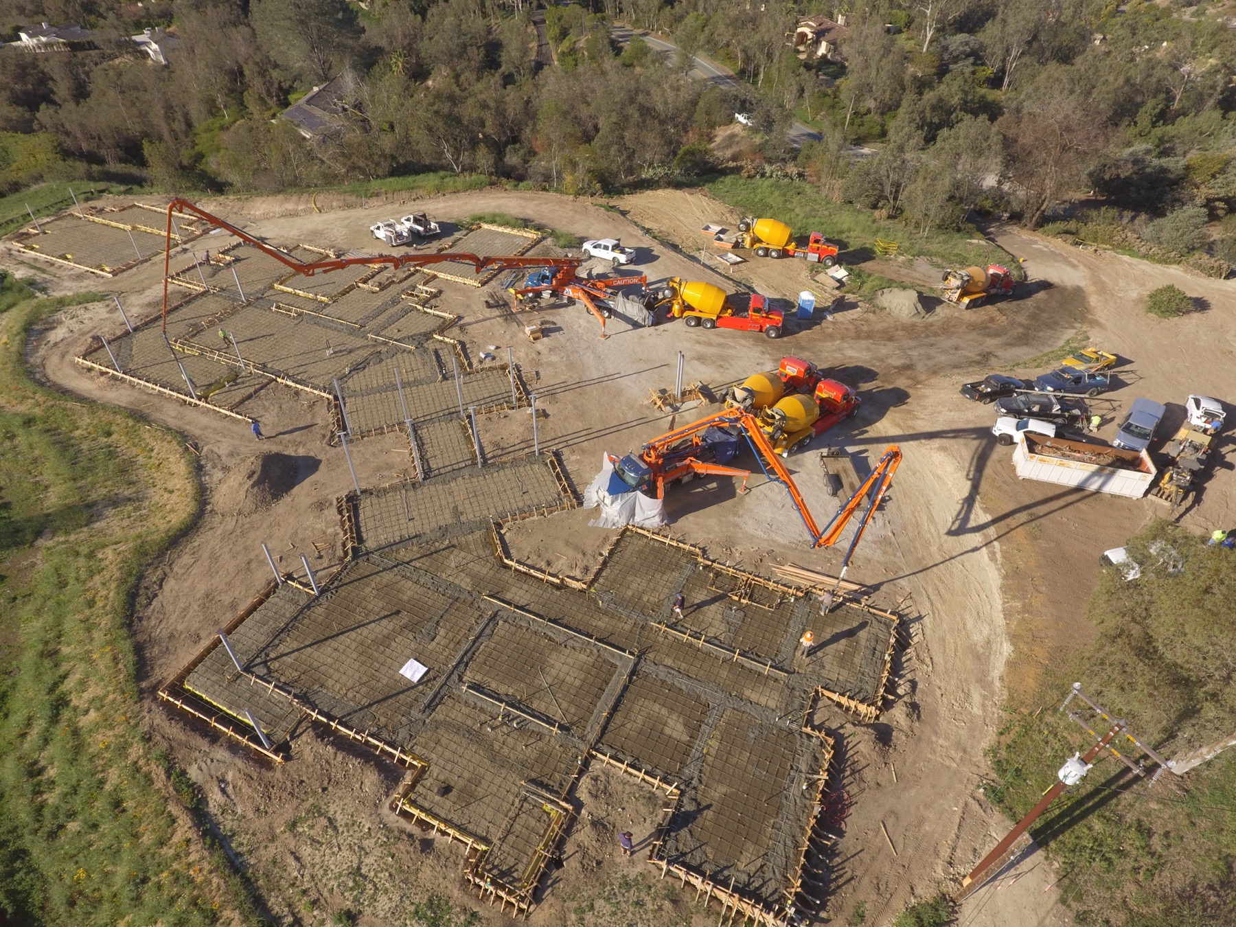 Drone aerial of the 4x8 foundation pour at Linea Del Cielo — footings, stem walls and pump crews