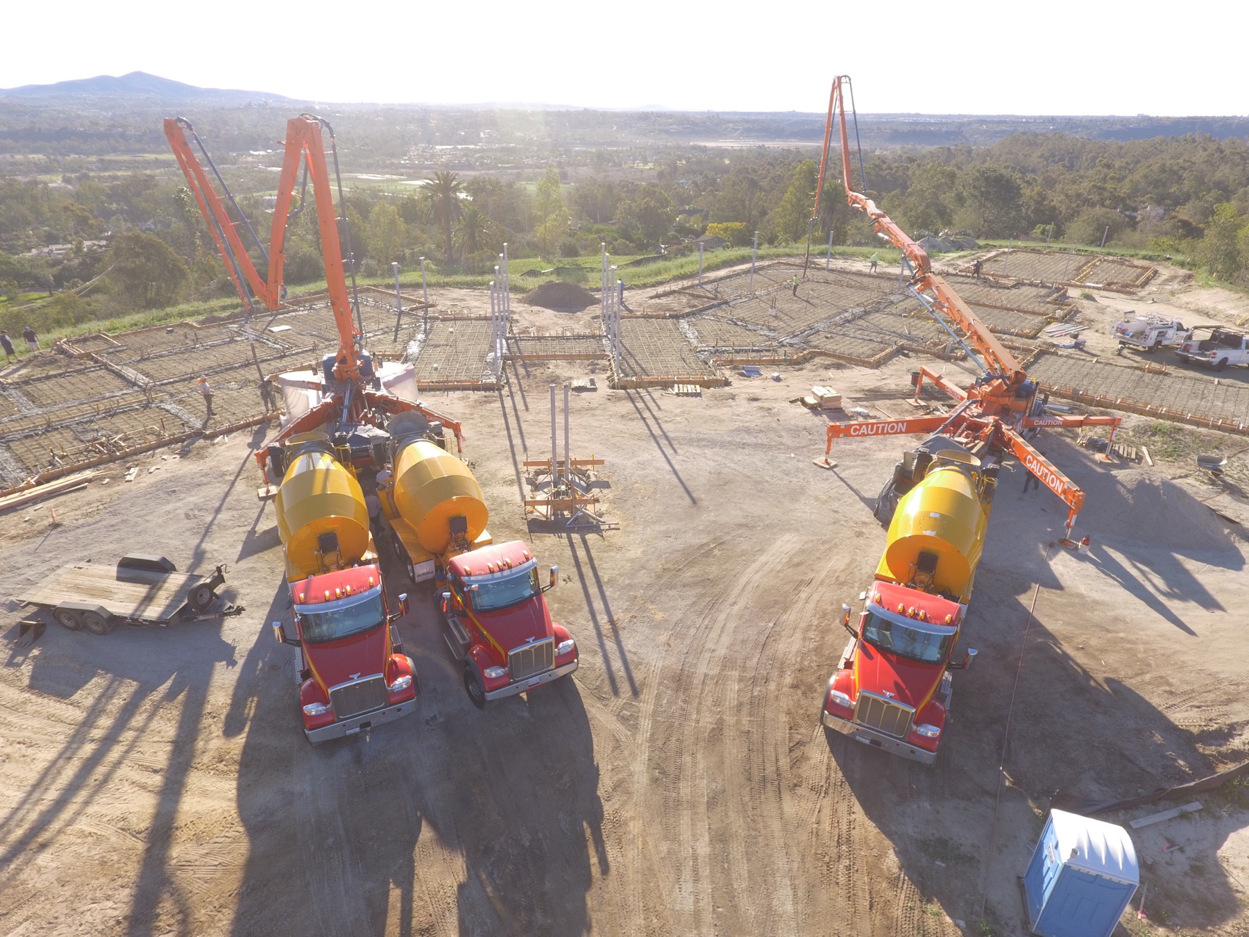 Drone aerial of the 4x8 foundation pour at Linea Del Cielo — footings, stem walls and pump crews
