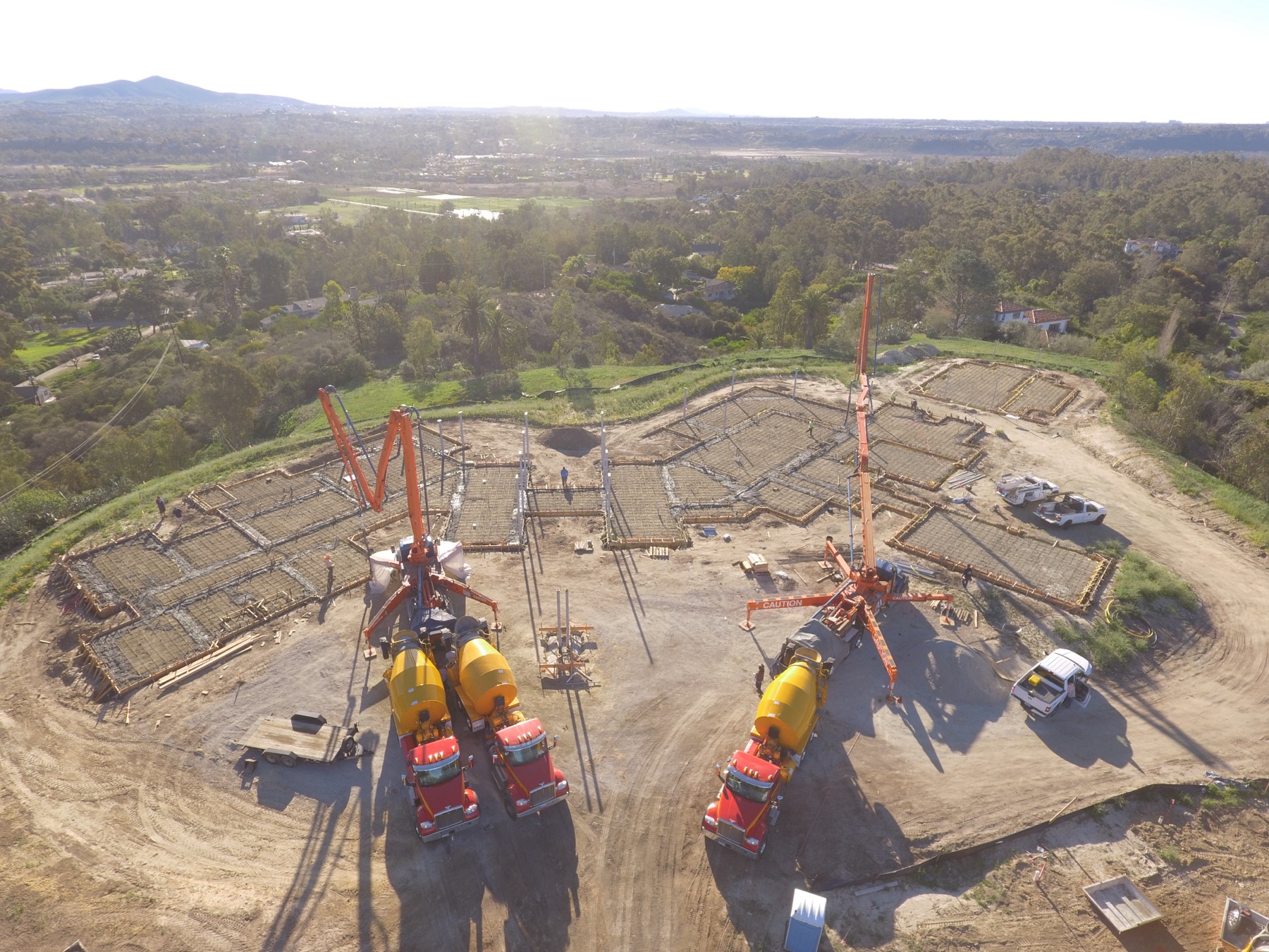 Drone aerial of the 4x8 foundation pour at Linea Del Cielo — footings, stem walls and pump crews