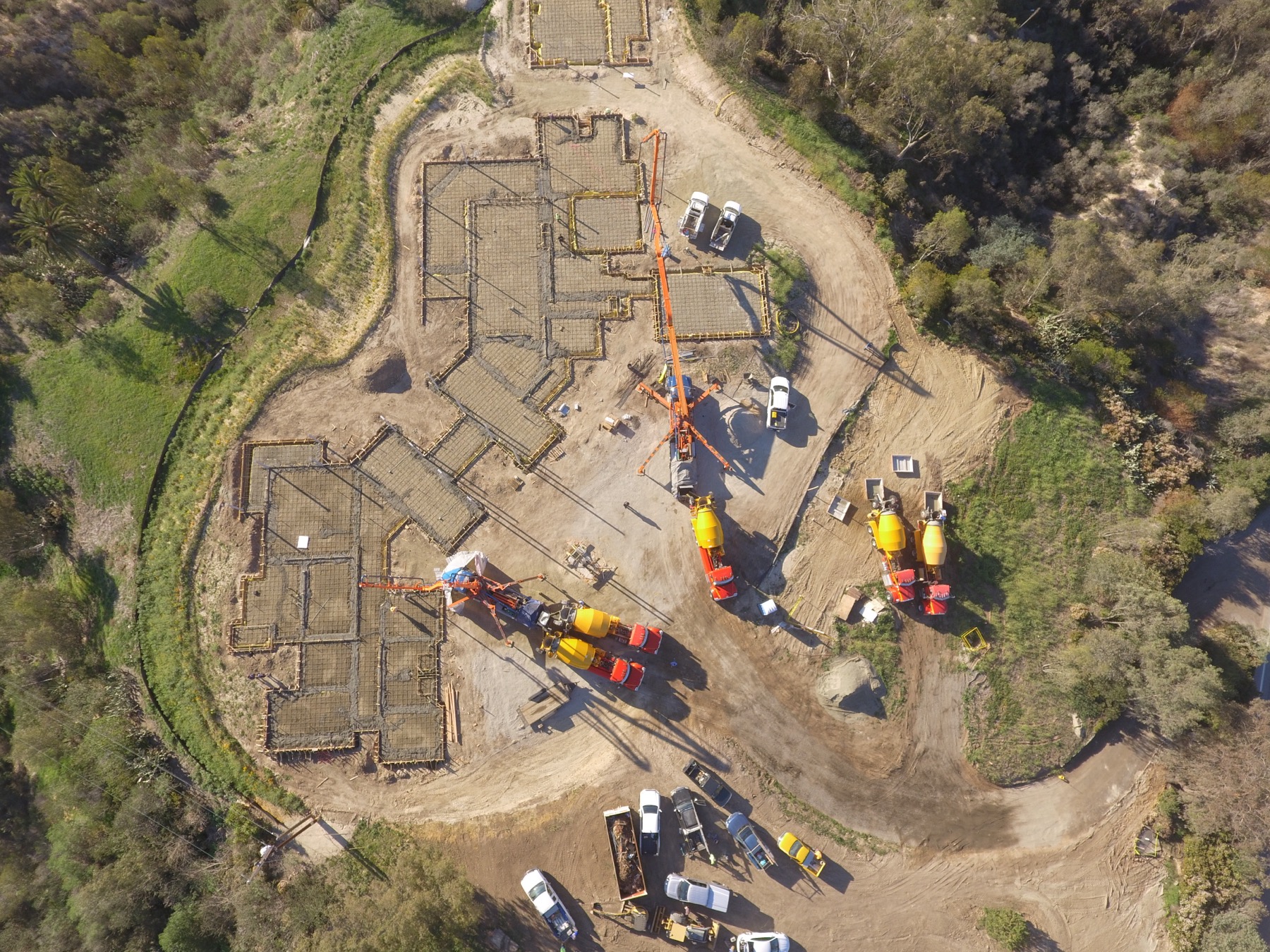 Drone aerial of the 4x8 foundation pour at Linea Del Cielo — footings, stem walls and pump crews