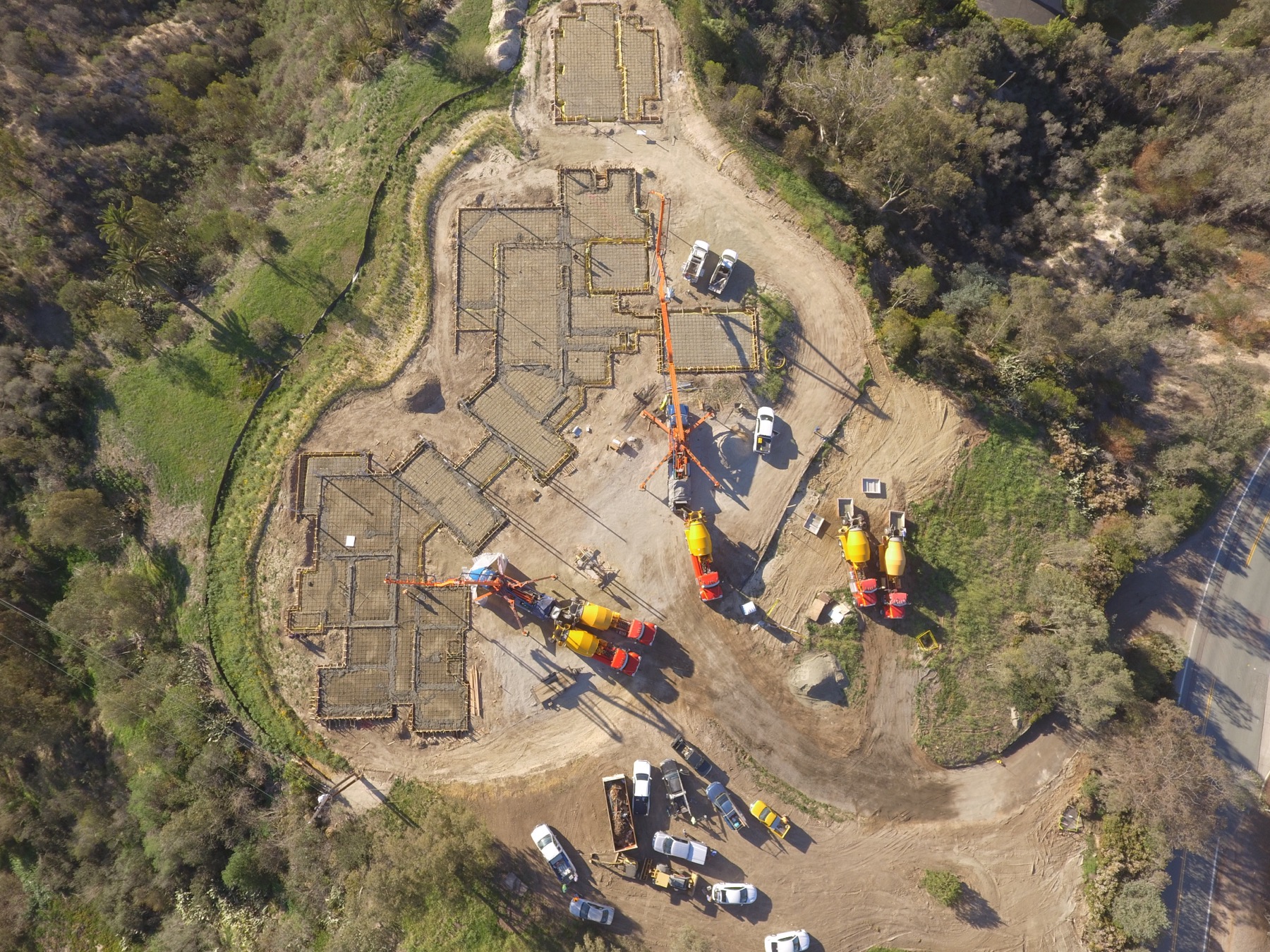 Drone aerial of the 4x8 foundation pour at Linea Del Cielo — footings, stem walls and pump crews