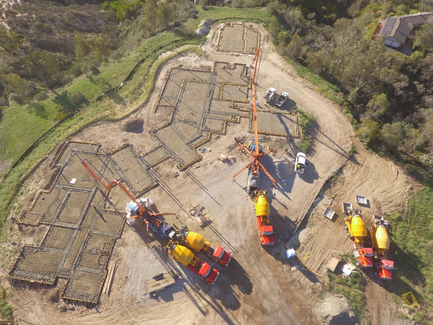 Drone aerial of the 4x8 foundation pour at Linea Del Cielo — footings, stem walls and pump crews