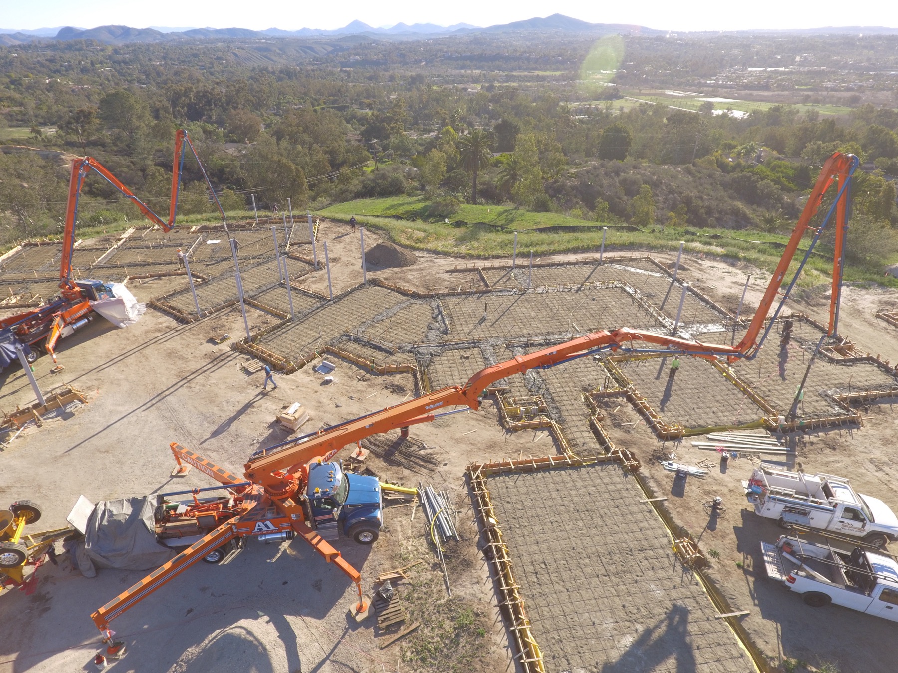 Drone aerial of the 4x8 foundation pour at Linea Del Cielo — footings, stem walls and pump crews