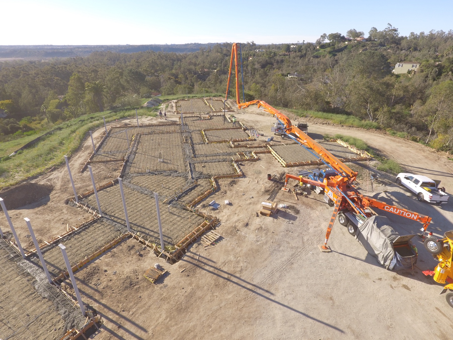 Drone aerial of the 4x8 foundation pour at Linea Del Cielo — footings, stem walls and pump crews