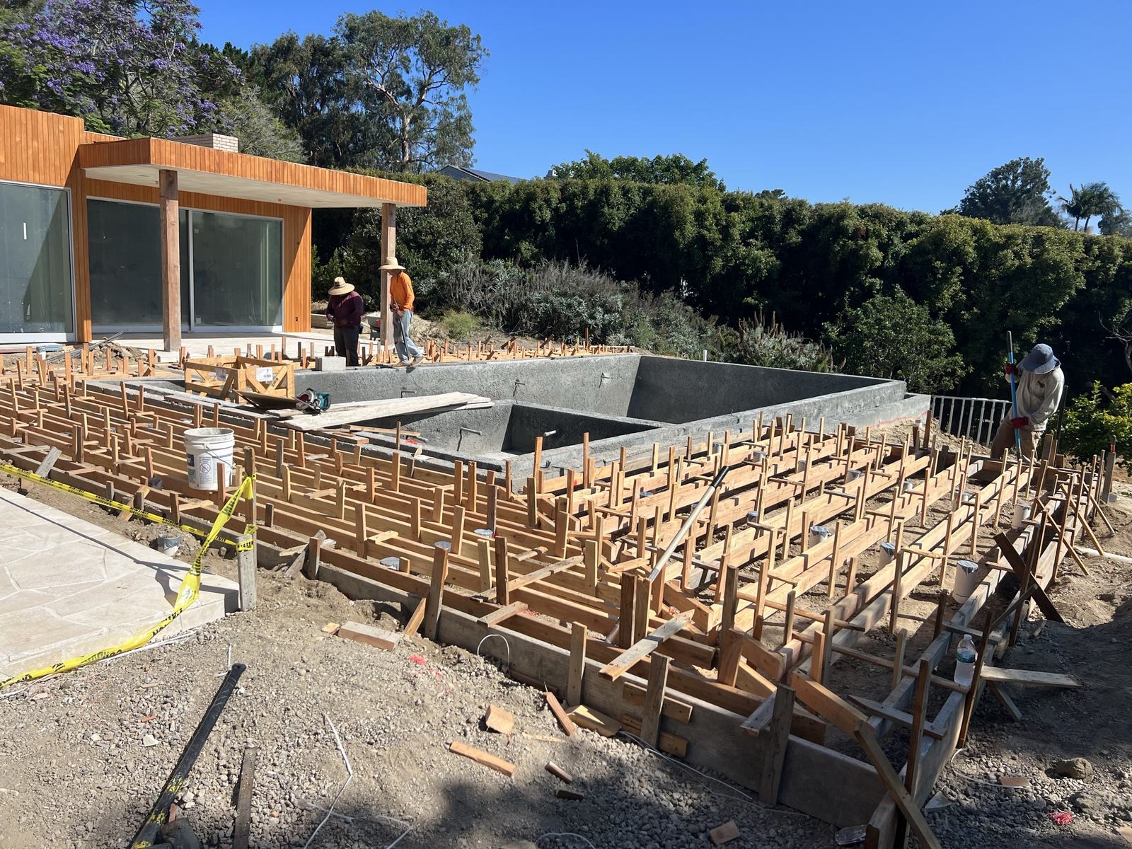 Stem wall formwork and pool shell with the cedar-clad house behind