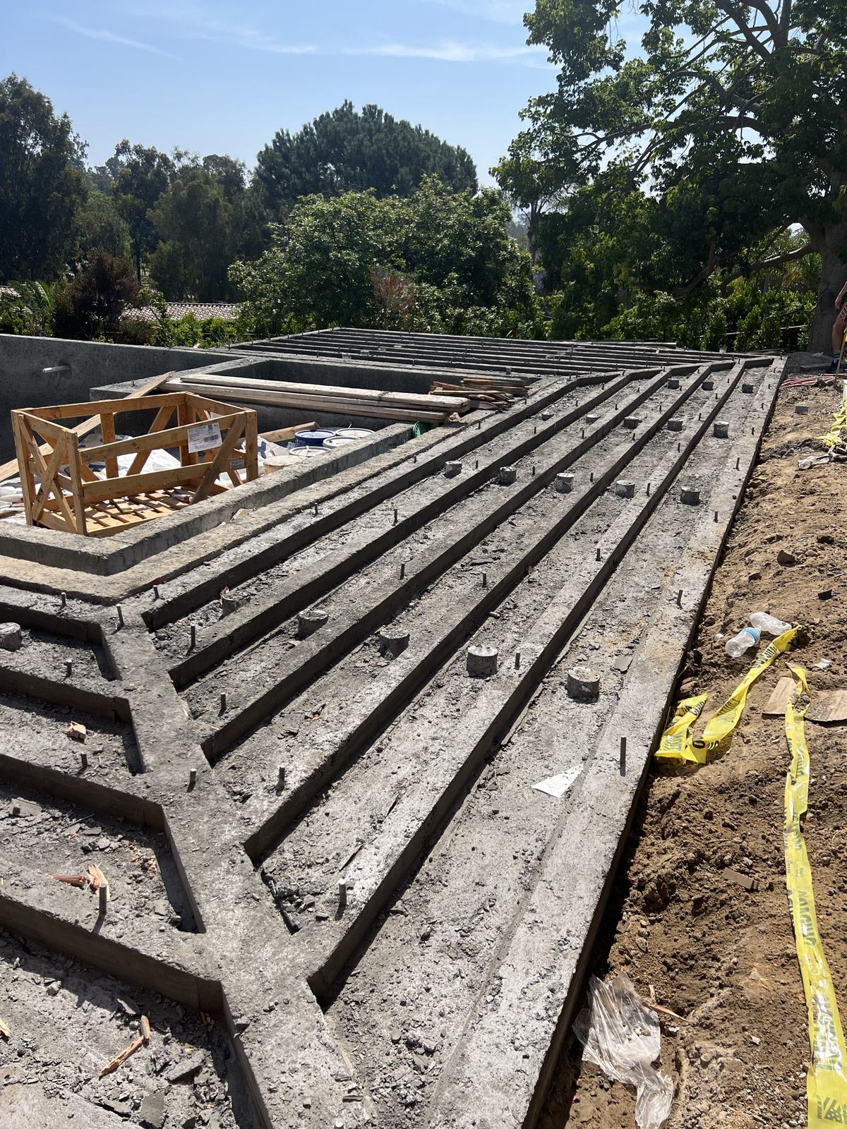 Poured stem walls and drainage channels beneath the future deck