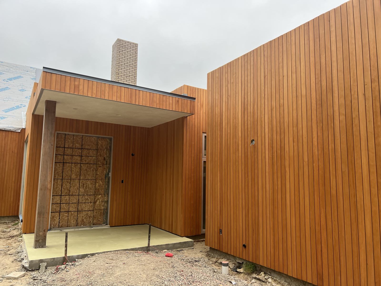 Cedar-clad entry with vertical-grain siding and soffit