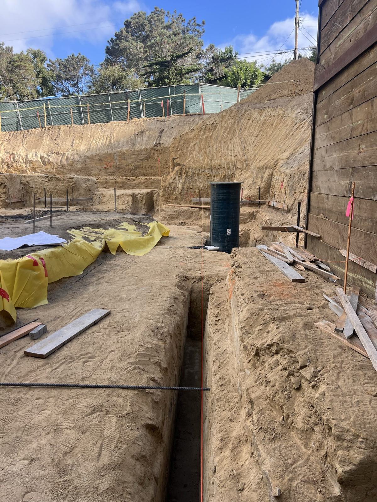 Footing trench excavated against the shored basement wall