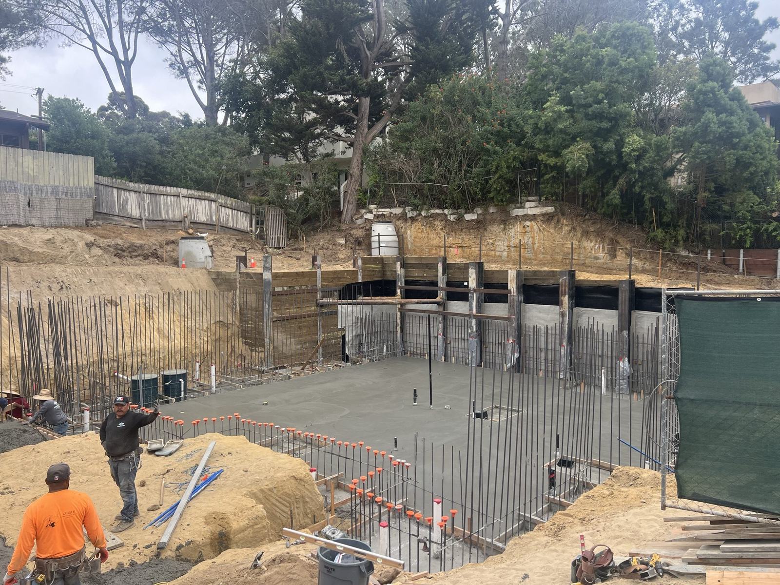 Basement slab pour in progress against the shoring wall