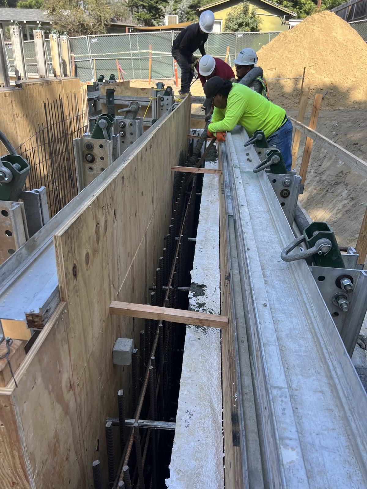 4x8 crew setting a waler on the basement wall formwork