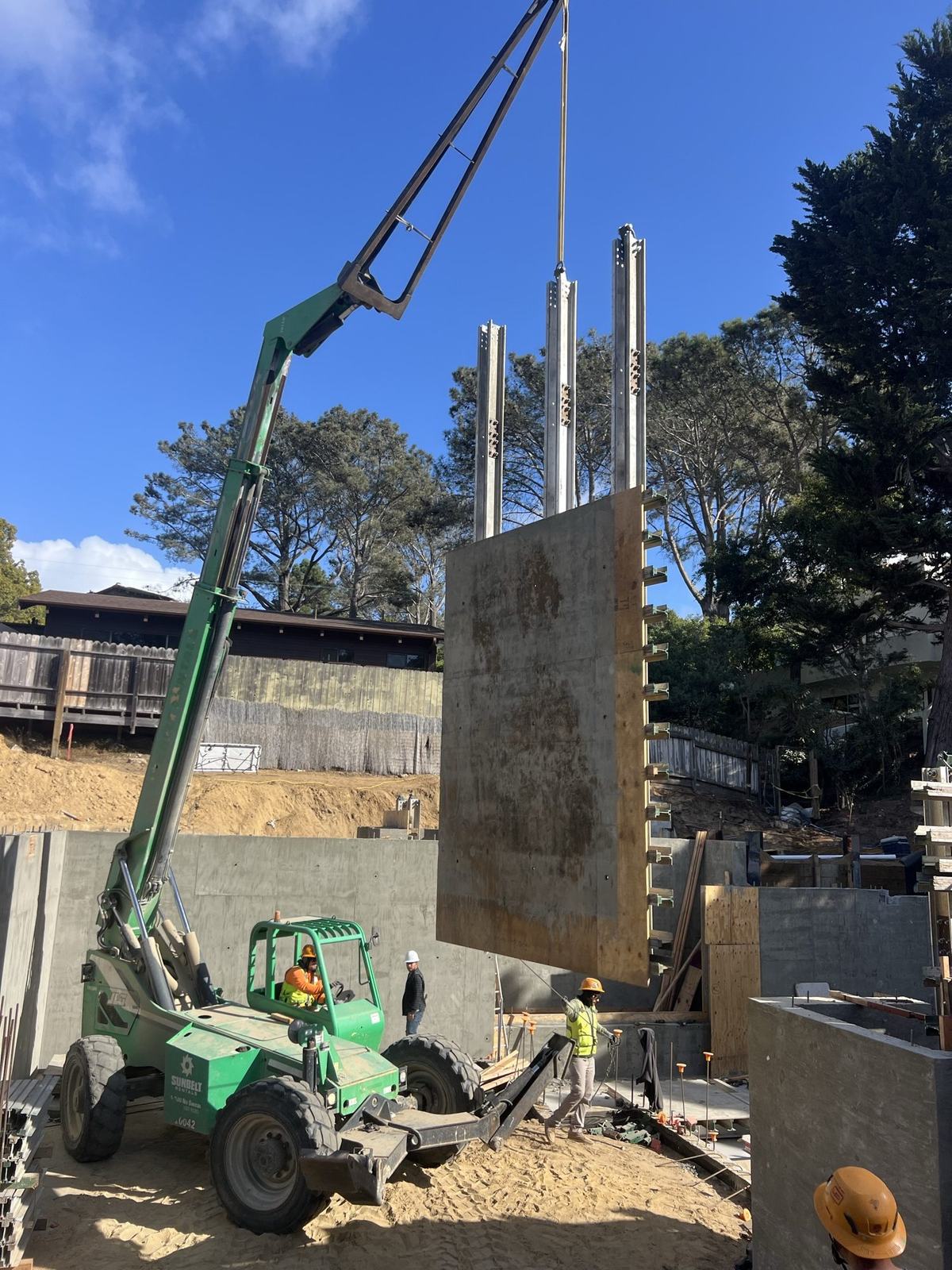 Form panel in the air above the completed basement wall