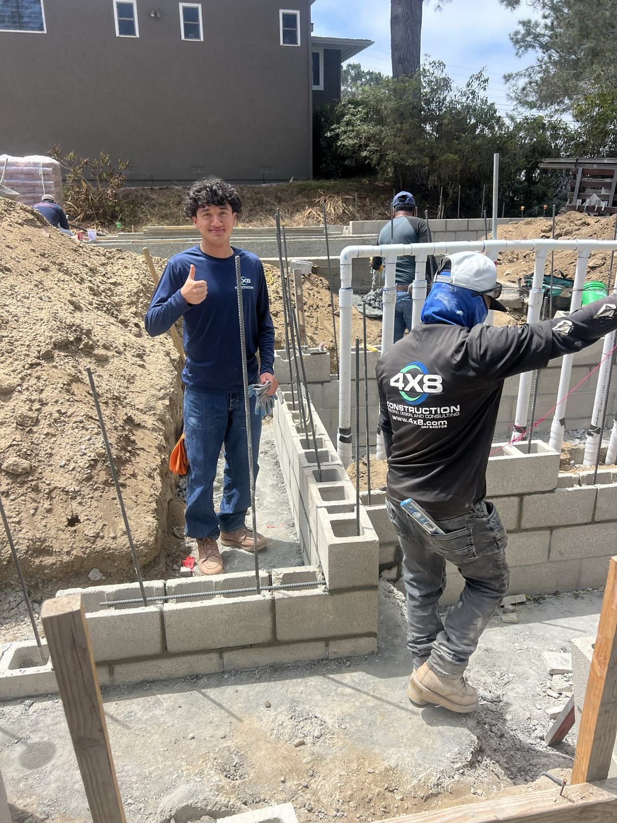 4x8 crew laying CMU block wall on site
