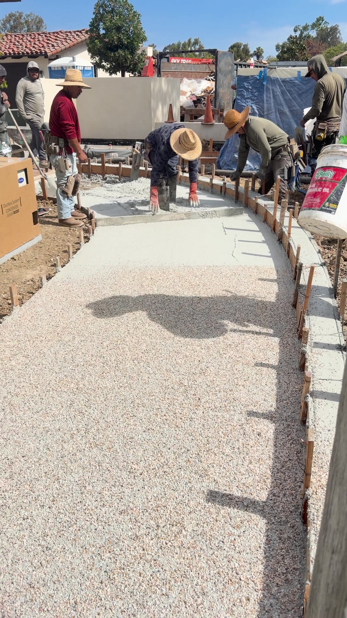 4x8 crew hand-seeding an exposed aggregate concrete walkway